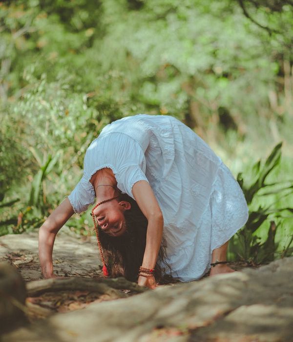 Woman practicing a serene yoga pose in a lush green park.